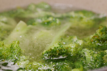 Fresh broccoli is being boiled until tender in a pot of water