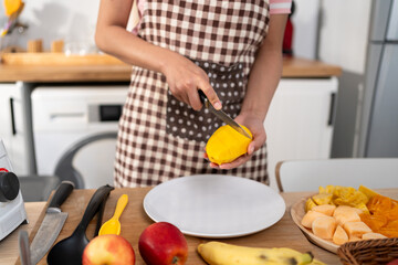 Close up of woman cooking healthy foods in kitchen in morning at home.