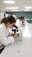 Obraz premium Young Scientists Examining Samples Under Microscope in Laboratory