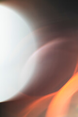 Soft-focus abstract image featuring blurred warm and cool light tones in motion.