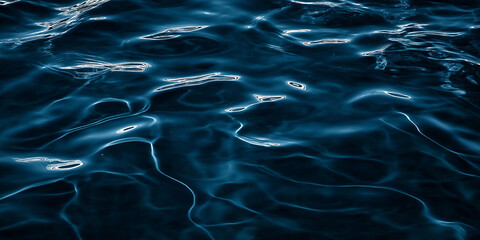 Dark blue water surface with gentle ripples reflecting light