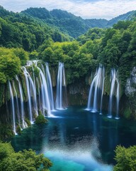 Fototapeta premium Serene waterfall cascade plunges into turquoise lake surrounded by lush green forest mountain landscape scenic nature photography
