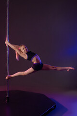 Girl performs impressive pole dance pose with elegant fabric style