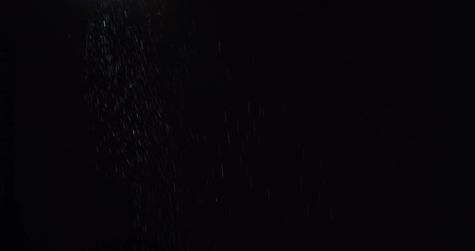 Water drizzle. Light snow. Defocused white color particles sparkles humid frost texture floating on dark black abstract art background.