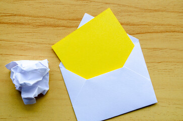 Top view of empty yellow notepad inside an envelope with crumpled paper with customizable space for...