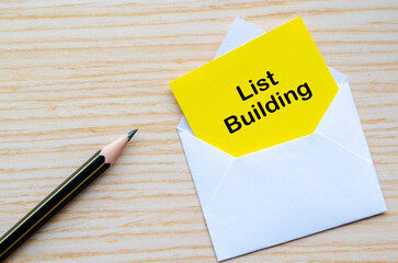List Building text on yellow notepad inside a white envelope. Making money online concept