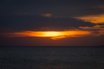 A serene seascape with a distant island silhouetted against the twilight sky