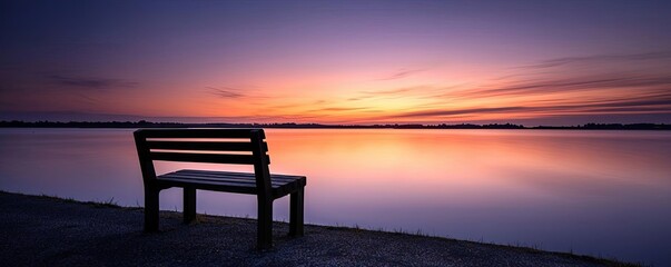 Lakeside sunset landscapes idea. A serene bench overlooking a calm lake at sunset, perfect for relaxation and reflection.