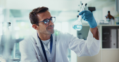 Scientist, man and smile with test tube in lab, review and chemical reaction for medicine development. Person, glass container and liquid for pharmaceutical, study and medical research for vaccine