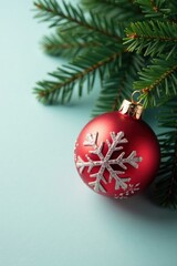 Snowflake-patterned glass ball ornament against a dark green fir branch flat lay, snowflake pattern, glass ornaments, decorative accents