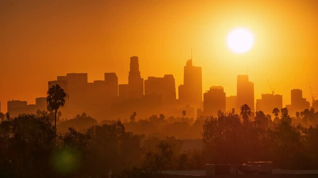 Sunrise sun raising over city skyline. Zoom in on iconic downtown Los Angeles skyline buildings. Timelapse.
