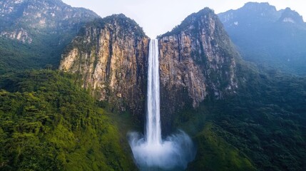 Fototapeta premium National park scenic landscapes idea. A breathtaking waterfall cascading down mountains, surrounded by lush greenery and mist.