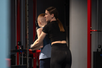 Teenager exercising on Multi-gym machine. Weight lifting exercises in the gym.