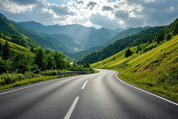 Naklejka premium Scenic winding road through lush green mountains under a partly cloudy sky.