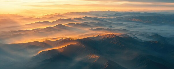 Mountain range landscapes idea. Breathtaking aerial view of serene mountains at sunset with golden hues.