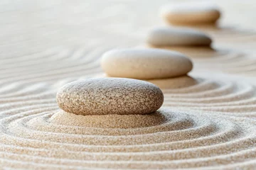 A close-up of perfectly arranged zen stones on a sand surface, conveying the art of balance and harmony in nature.