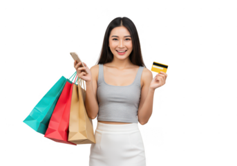 A smiling woman holds shopping bags phone and credit card against a black background studio shot