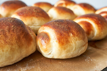 Freshly baked scones on baking paper, close-up.