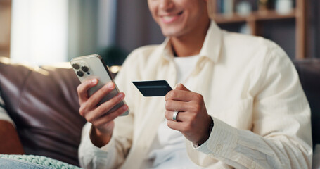 Credit card, phone and hands of man on sofa for online shopping, internet banking or payment in...