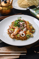 a plate of fried noodles with shrimp and vegetables
