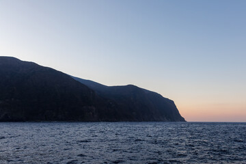 Naklejka premium 珍しく穏やかに凪いだ、夜明けの御蔵島、御蔵島港。 東海汽船東京湾〜伊豆諸島八丈島、太平洋航路の橘丸船上 -2025 