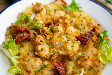 A Spanish tapa of Tortillas de camarones. Small portions of fried fritters with shrimp and vegetables.