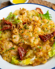 A Spanish tapa of Tortillas de camarones. Small portions of fried fritters with shrimp and vegetables.