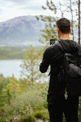 Backview of hiker taking photo of scenic view in Canmore, Alberta
