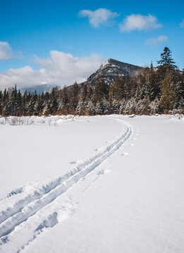 Fresh ski tracks through beautiful snow with mountains, Maine