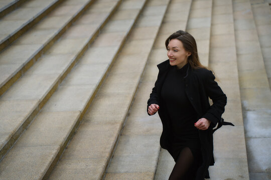 Redhead woman running up staircase in the city downtown