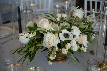 A luxurious white floral centerpiece with roses and anemones