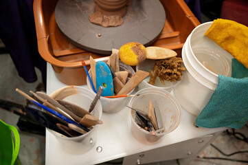Collection of pottery tools near a spinning wheel