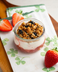 Greek yogurt with strawberries and granola made with cereals and nuts.