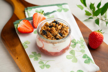 Greek yogurt with strawberries and granola made with cereals and nuts.