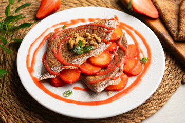 Chocolate crepes with fruit, strawberries and bananas.