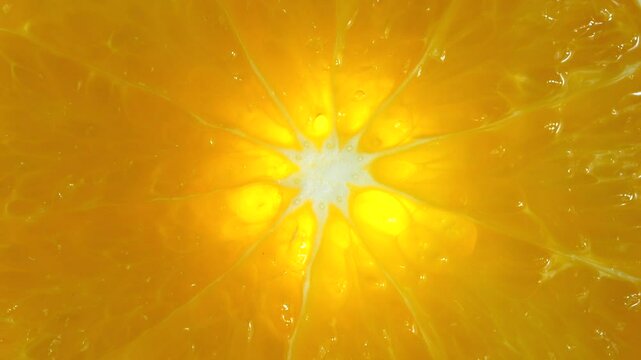 Macro video of mandarin slice kept on rotating disc. Half orange slice rotating.