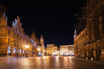 Fototapeta premium Vibrant night life illuminates the historic Old Town Square in Torun, Poland