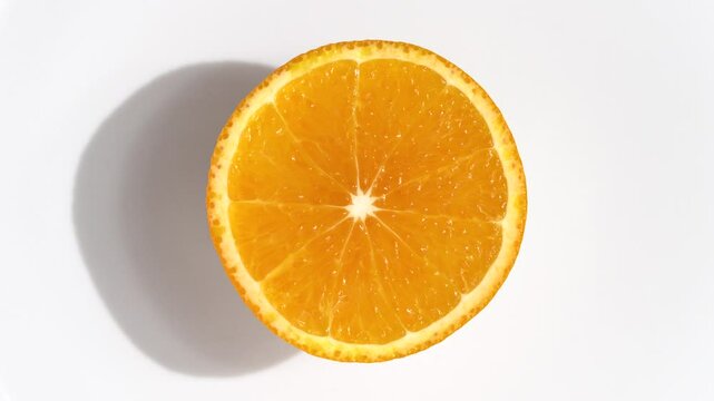 Macro video of mandarin slice kept on rotating disc. Half orange slice rotating.