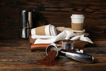 Scoops of coffee powder, beans and cups on dark wooden table