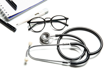 Stethoscope and glasses on white background