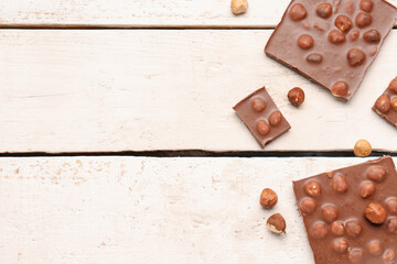 Sweet tasty chocolate with nuts on  light wooden background