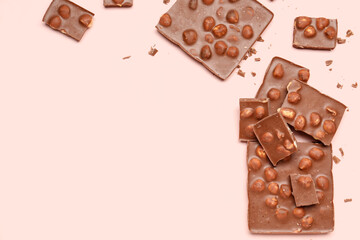 Sweet tasty chocolate with nuts on  light pink background