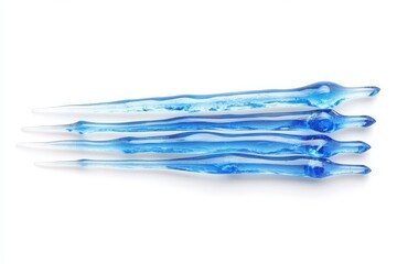 Fototapeta premium A close up of four blue glass icicles arranged horizontally on a white background studio shot design