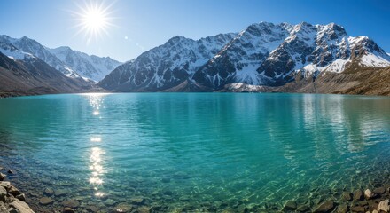 Obraz premium Turquoise Lake Reflecting Snow Covered Mountains on a Bright Sunny Day