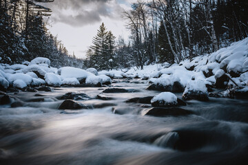 Rushing waters of Carrabassett River in idyllic winter scene