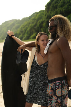 Happy friends with surfboards on the beach