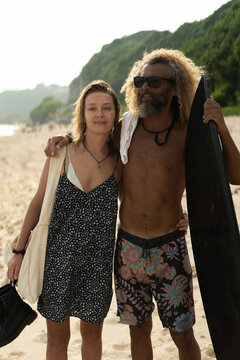Happy friends with surfboards on the beach
