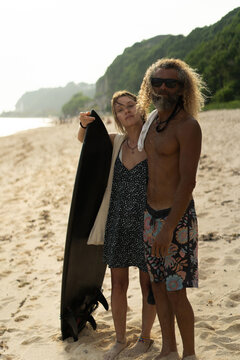 Happy friends with surfboards on the beach