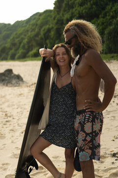 Happy friends with surfboards on the beach