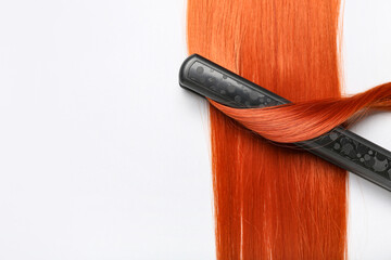 Ginger hair with straightening iron on white background, closeup